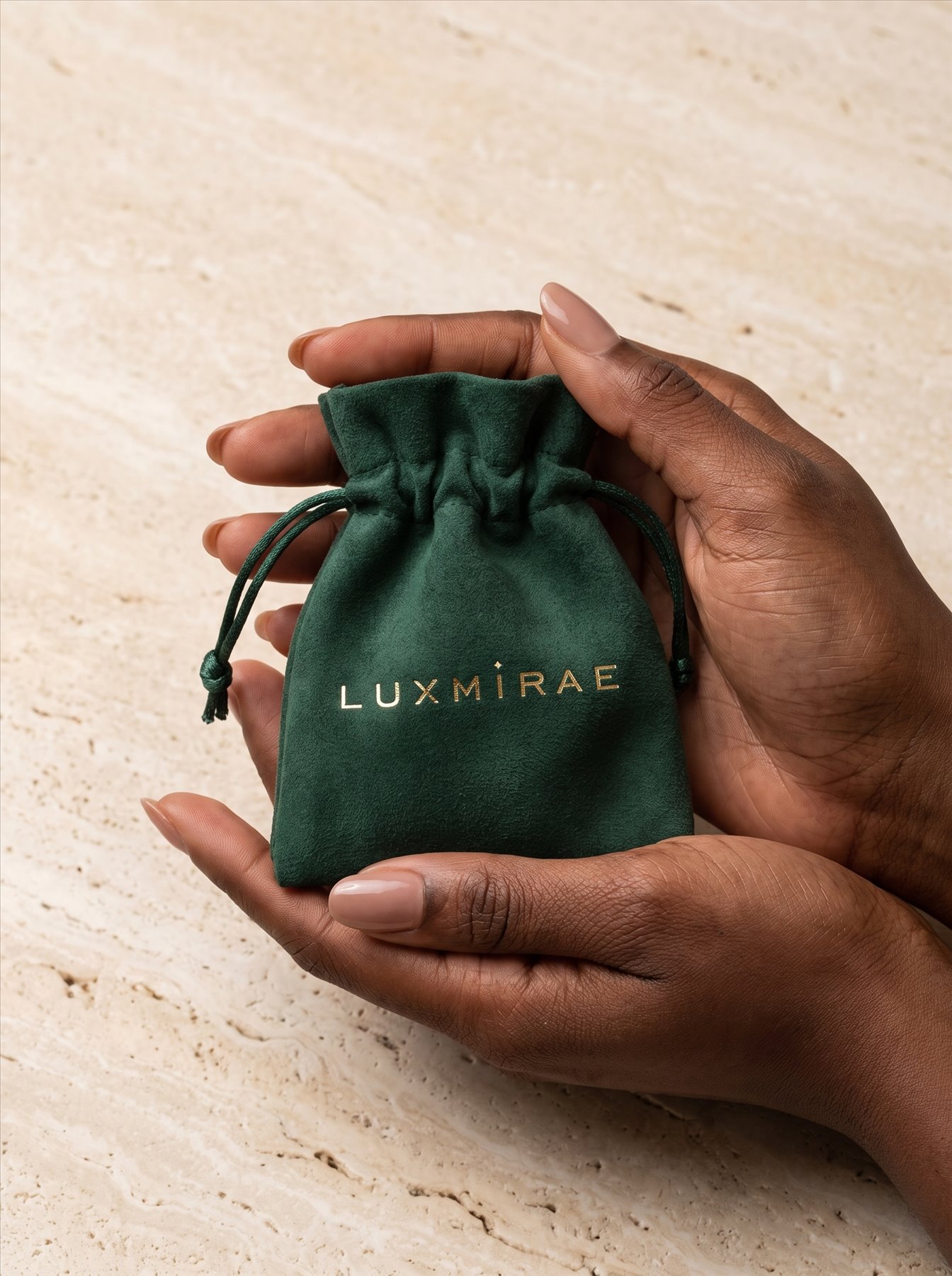 Green Luxmirae jewellery pouch held in both hands